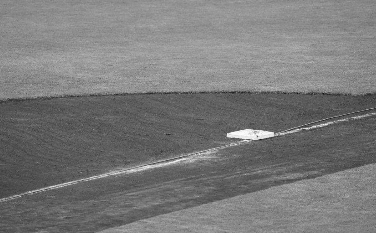 A close-up view of a baseball field with one of the bases in detail.